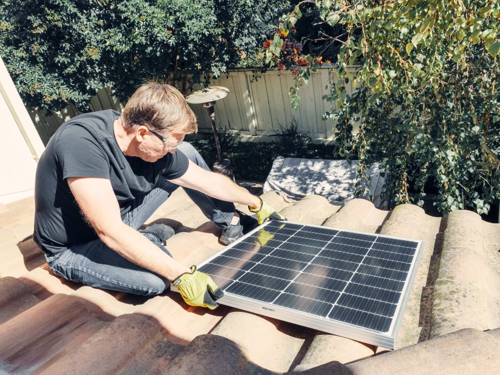 Man installing a solar panel on a roof